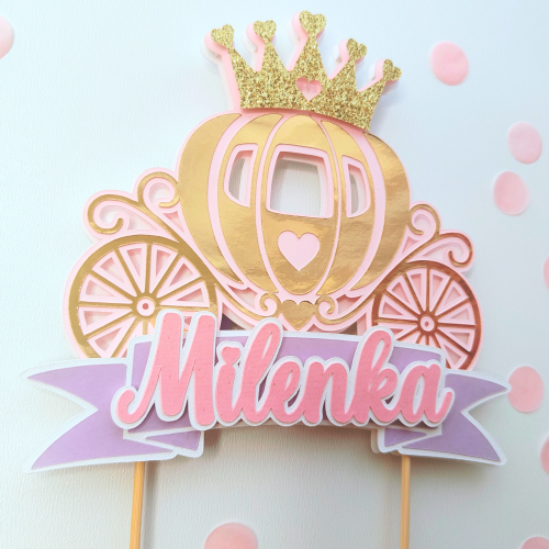 Topper na tort w kształcie bogato zdobionej karocy z koroną na szczycie i fioletową wstęgą z imieniem, personalizowany. Kolorystyka różowo-złota z lustrzanym efektem.