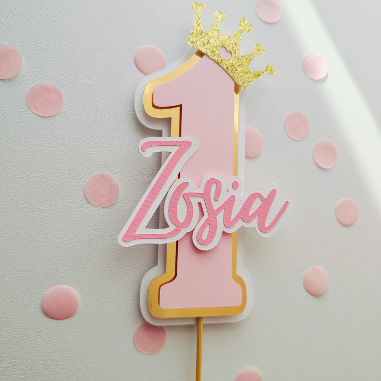 Różowy topper na tort w kształcie cyfry 1 z imieniem Zosia i złotą brokatową koroną, dekoracja na pierwsze urodziny dla dziewczynki.