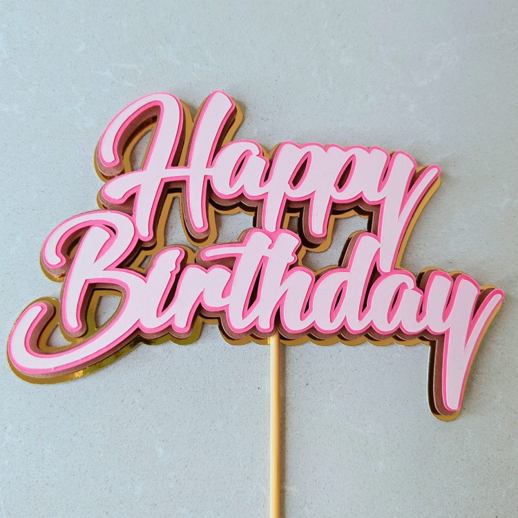Trójwymiarowy topper na tort z napisem Happy Birthday. Warstwy w kolorze jasnoróżowym i ciemnoróżowym na złotym, lustrzanym podkładzie.