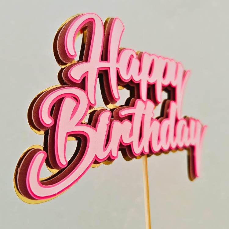 Trójwymiarowy topper na tort z napisem Happy Birthday. Warstwy w kolorze jasnoróżowym i ciemnoróżowym na złotym, lustrzanym podkładzie.