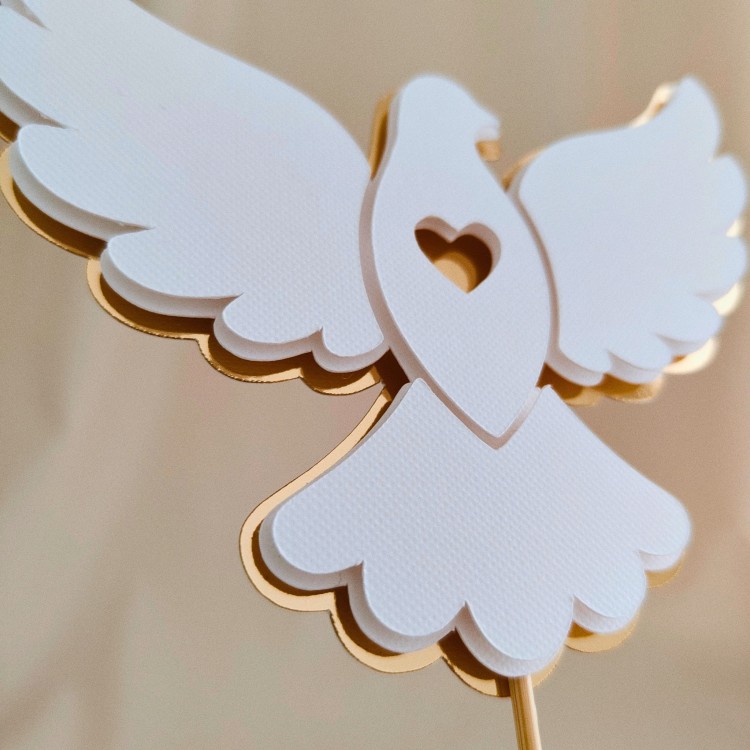 Elegancki, przestrzenny topper na tort w kształcie gołąbka (efekt 3D). Klasyczne połączenie fakturowanej bieli i złotego lustra z uroczym wycięciem w kształcie serduszka. Idealna, gotowa do wysyłki dekoracja na Chrzest Święty lub Komunię.