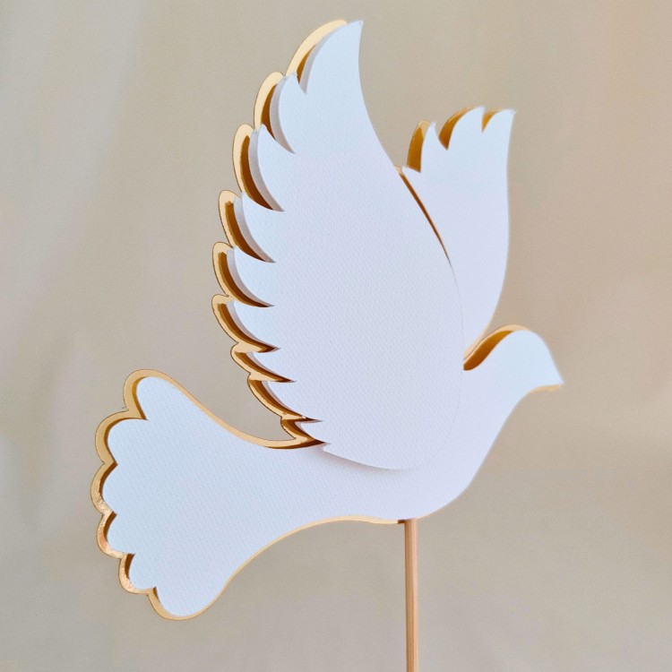 Elegancki, przestrzenny topper na tort w kształcie lecącego gołąbka (efekt 3D). Wzór wykonany z fakturowanego, białego papieru na podkładzie ze złotego lustra. Idealna, gotowa dekoracja na Chrzest Święty lub Komunię.
