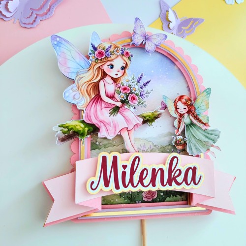 Bajkowy, personalizowany topper na tort urodzinowy (spektakularny efekt 3D). Wielowarstwowa kompozycja z motywem uroczych wróżek, kwiatów i motyli, oprawiona w pastelowe i złote ramki. Zawiera wypukłą szarfę z imieniem dziecka.