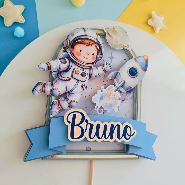 Kosmiczny, personalizowany topper na tort urodzinowy (spektakularny efekt 3D!). Wielowarstwowa kompozycja z uroczych astronautą, rakietą i planetami, oprawiona w niebiesko-złotą ramkę. Idealna dekoracja dla małego fana kosmosu!